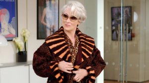 Film: The Devil Wears Prada. Miranda Priestly (Meryl Streep) wears a reddish brown Persian lamb with Persian lamb and leather stripe collar and cuffs by Fendi; cheetah print silk