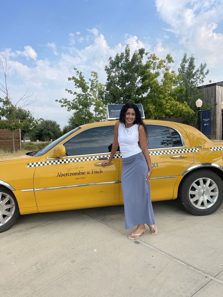 Guest beside an Abercrombie branded yellow taxi
