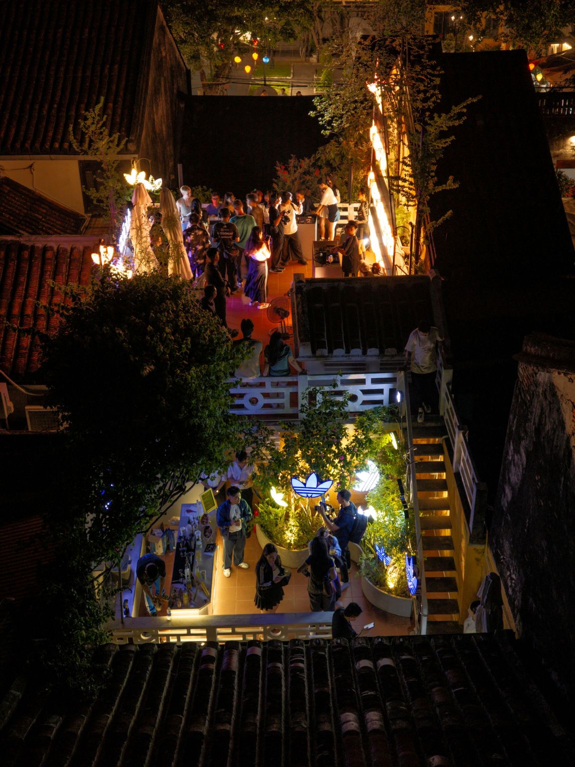 Guests gathering on the rooftop of the adidas Originals Hoi An store at night