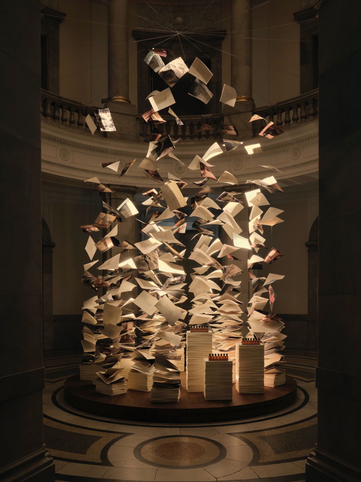 Suspended book pages above a fragrance display at Aesop’s Of Scent and Stanza exhibition in Tokyo