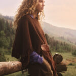 Anthropologie fall campaign model beside a wooden fence.