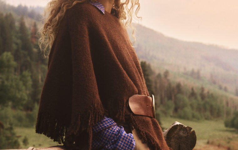 Anthropologie fall campaign model beside a wooden fence.