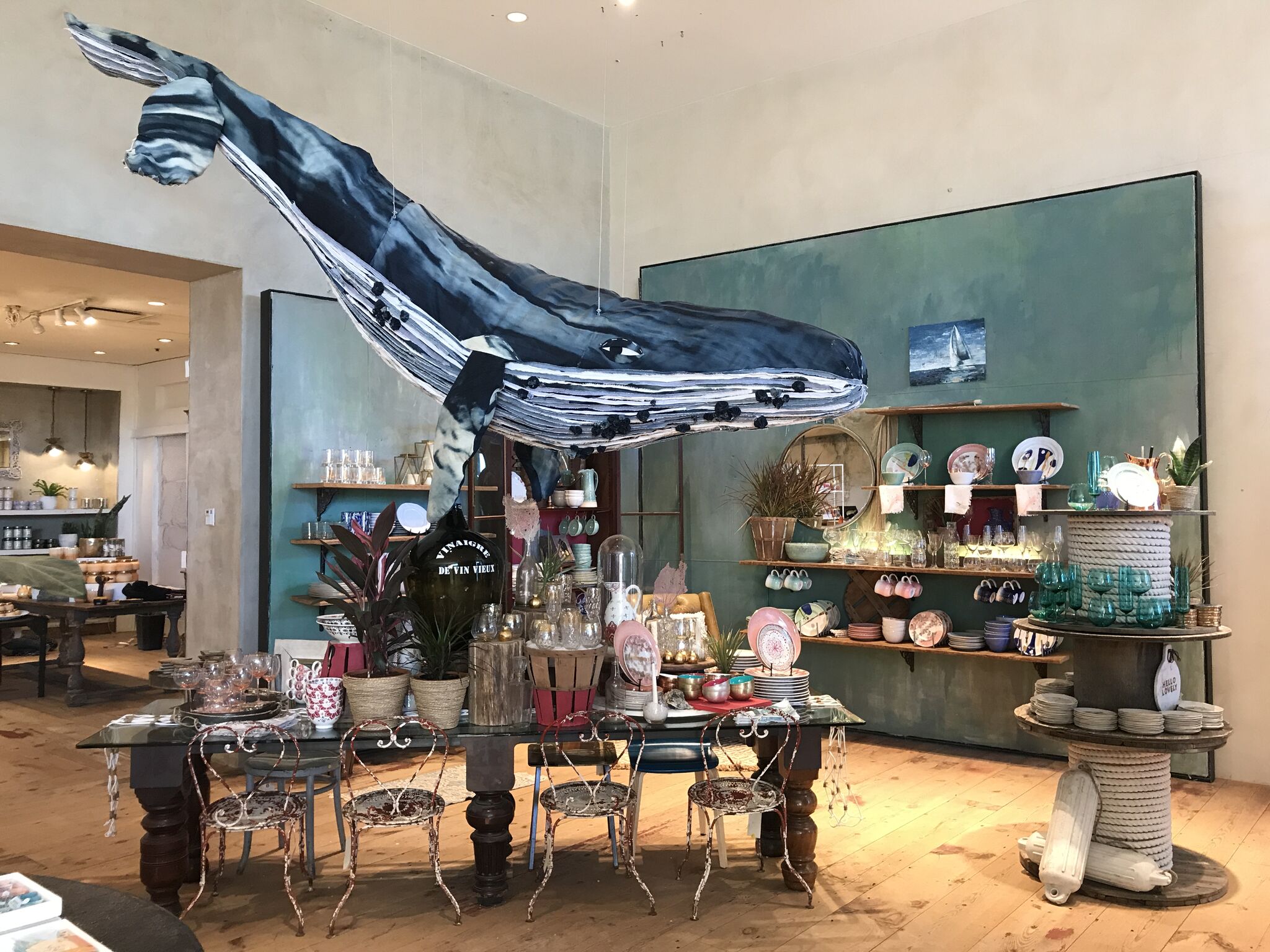 An oversized denim whale suspended above Anthropologie homeware tables and shelves