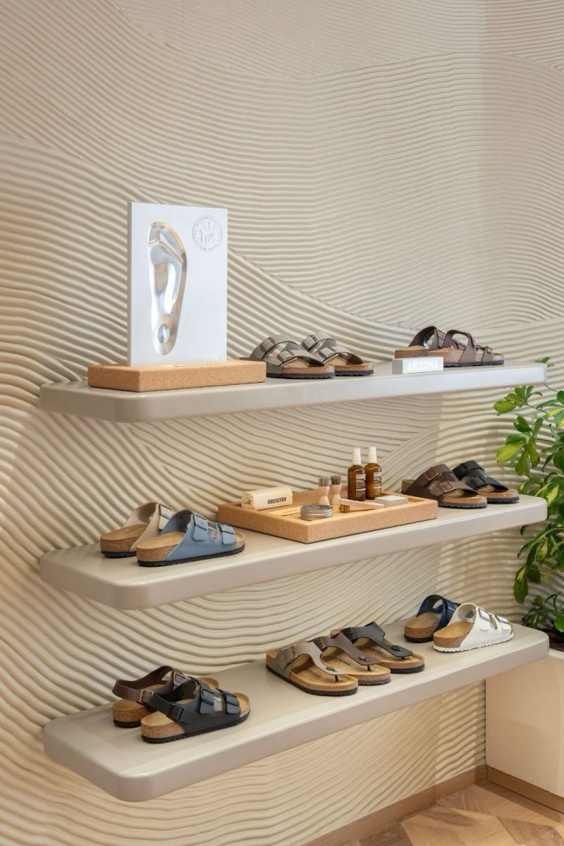 Birkenstock sandals and care products displayed against textured walls in Dubai