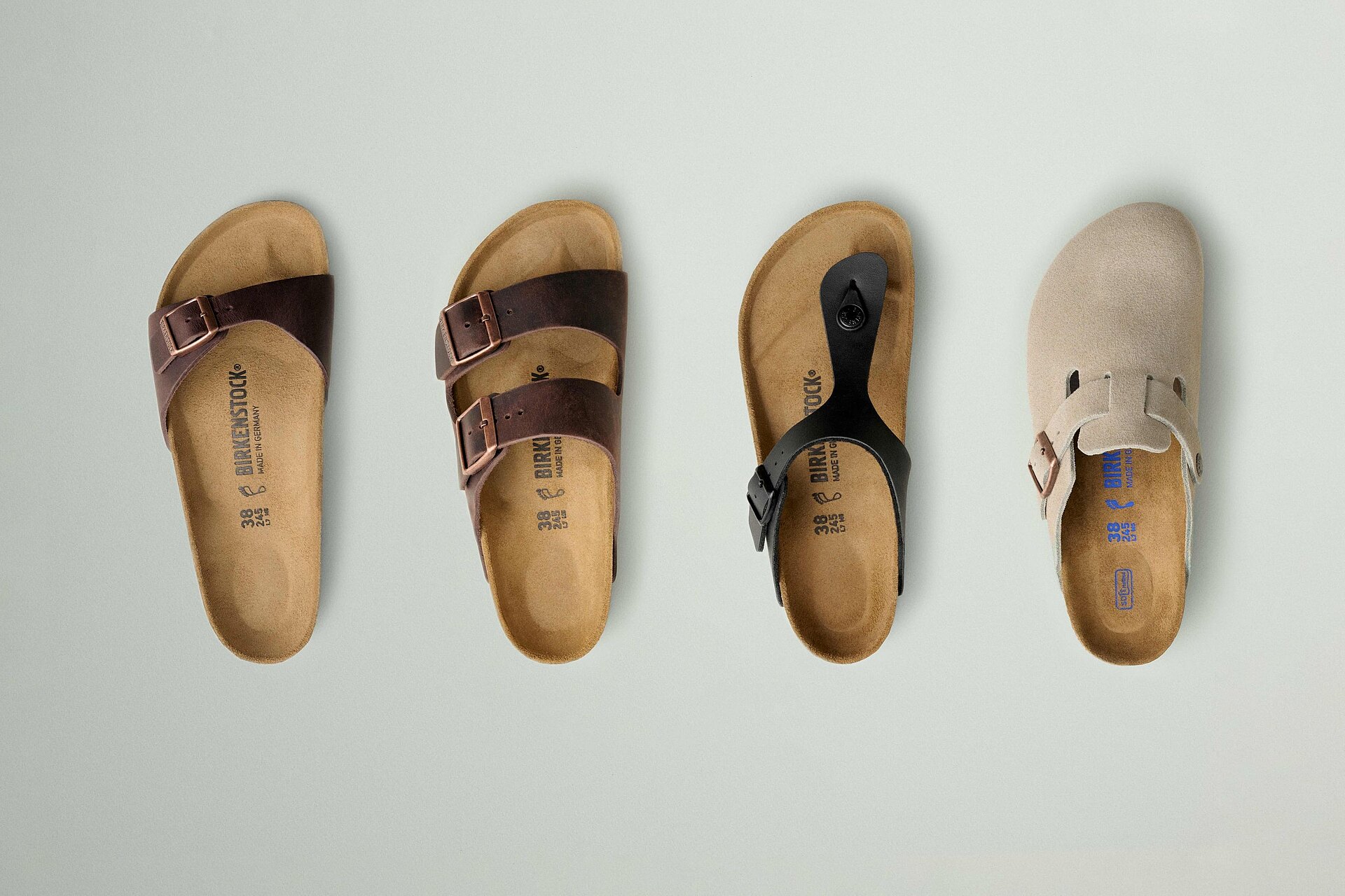 Four classic Birkenstock sandals photographed from above, showing their contoured footbeds