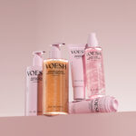 Pink VOESH body-care packaging arranged on a pink background.