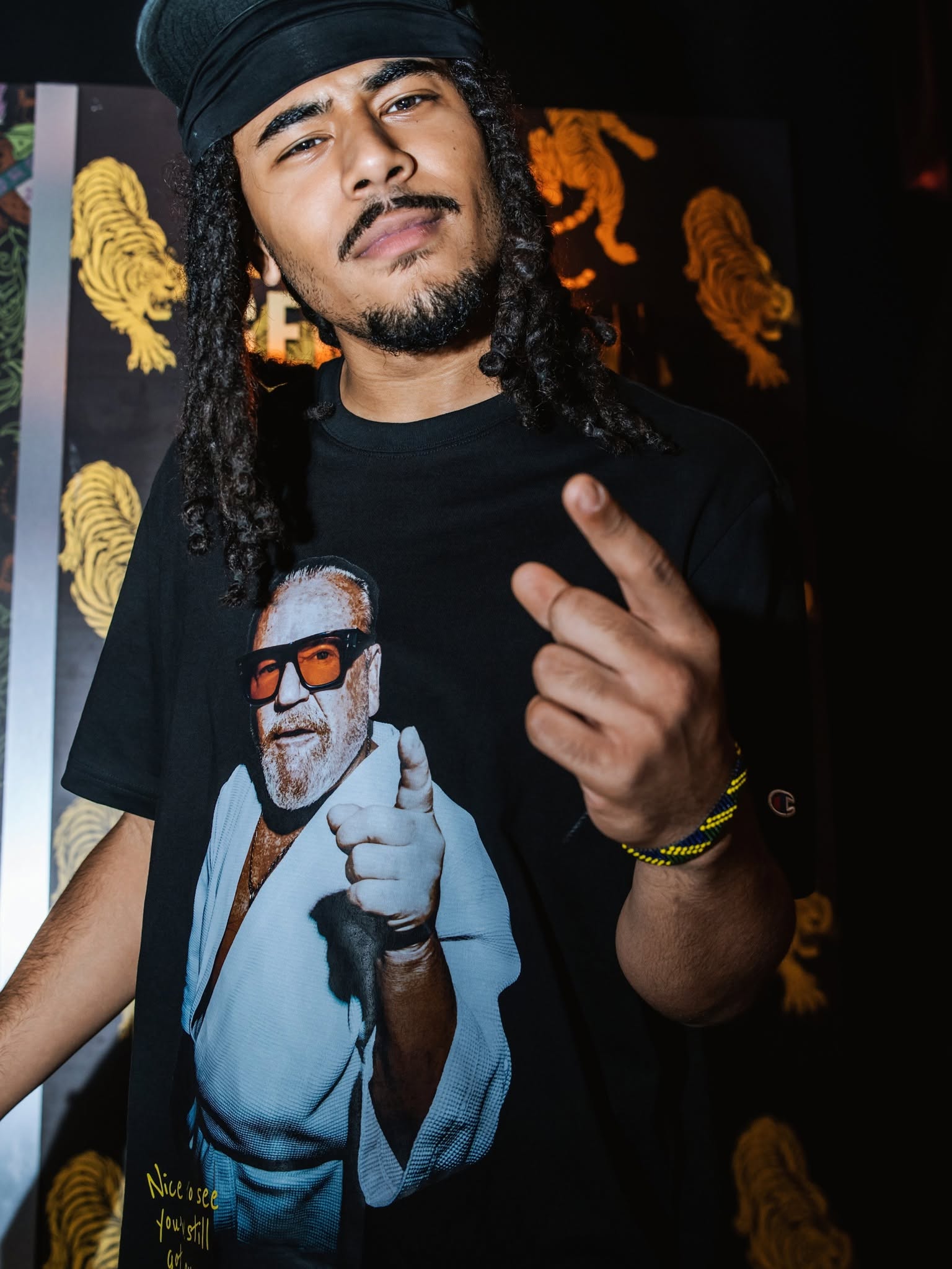 Guest wearing a graphic Champion T-shirt at The Gentlemen launch event.