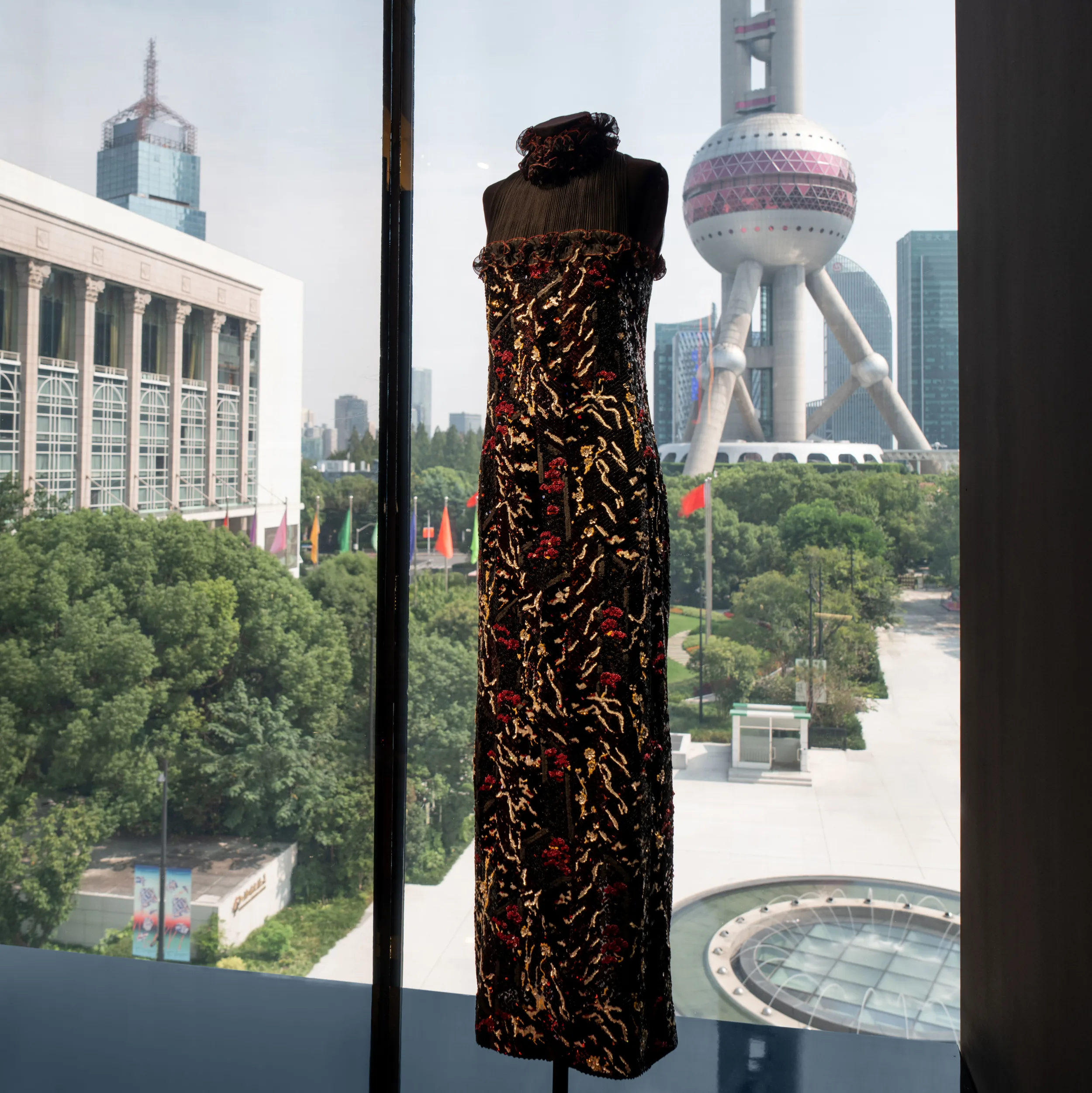Embroidered Lesage garment displayed against the Shanghai skyline at the Museum of Art Pudong