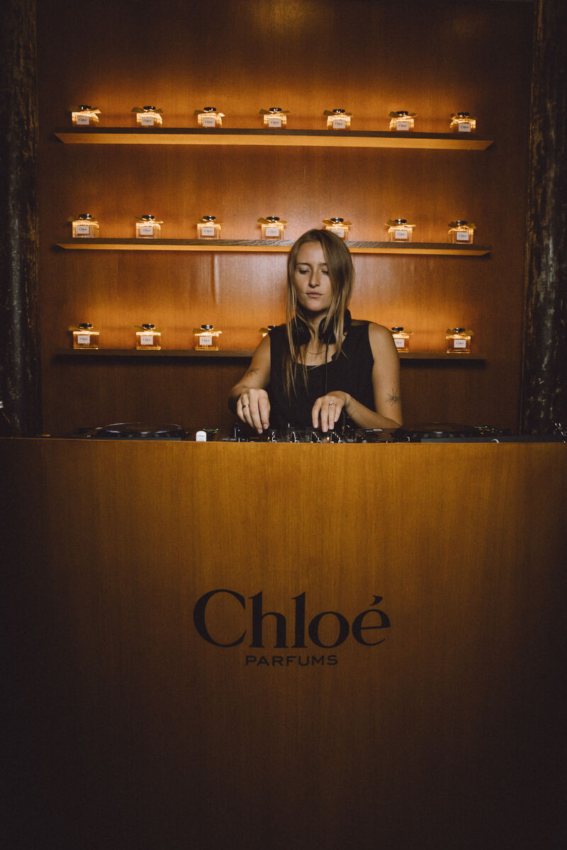 DJ performing in front of a Chloé Parfums display