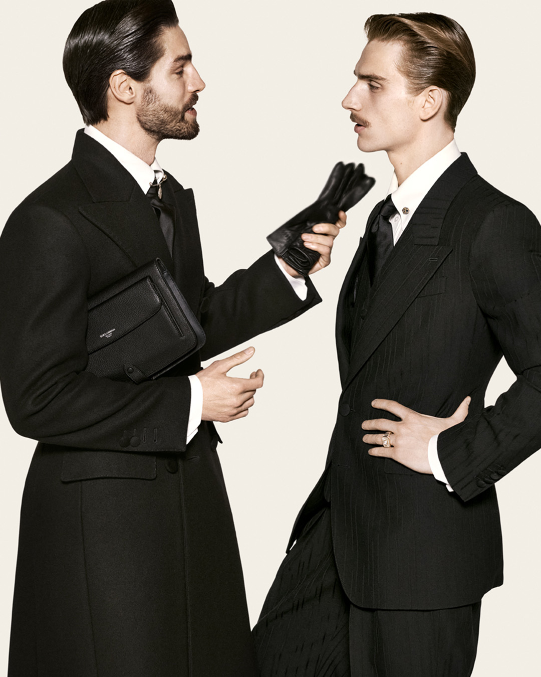 Two models in black tailoring with leather accessories