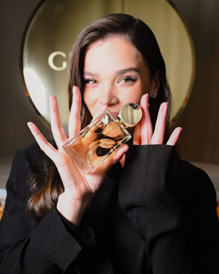 Hailee Steinfeld holds Estée Lauder Glimmer fragrance at the New York launch event