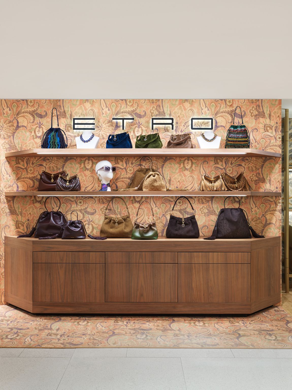 Etro handbags and jewelry displayed on a wood fixture at La Rinascente Milano