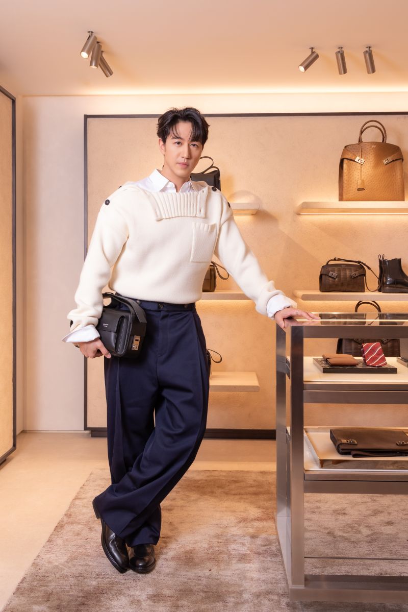 Guest inside Ferragamo's LANDMARK Hong Kong boutique beside leather goods