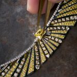 An artisan working on a FRED jewel with yellow and white stones