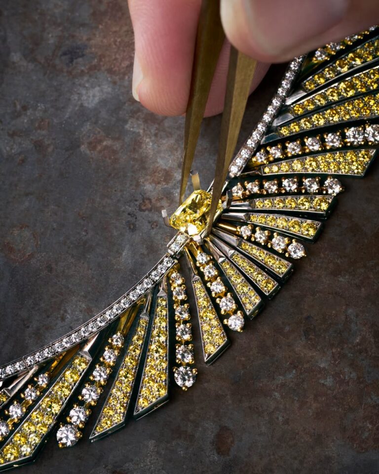 An artisan working on a FRED jewel with yellow and white stones