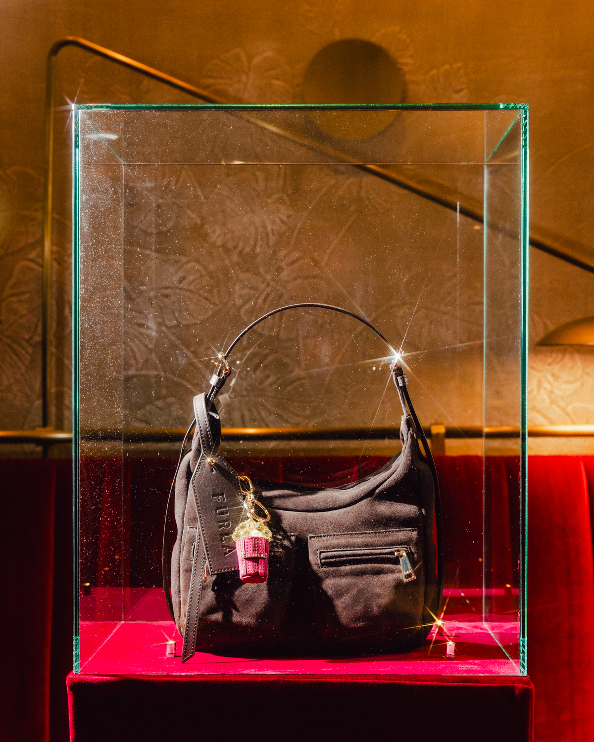 Furla Lynette bag displayed with a cinema-themed popcorn charm