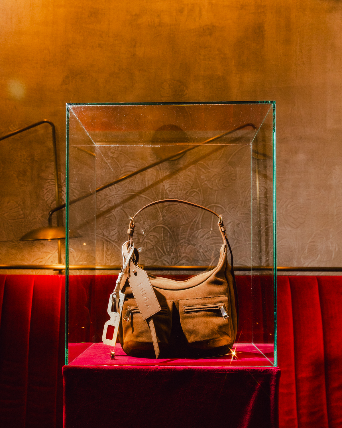 Cognac Furla Lynette bag displayed at the Milan event