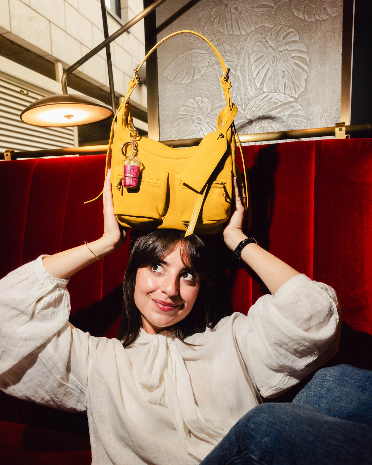 Furla event guest holding a yellow Lynette bag with a popcorn charm