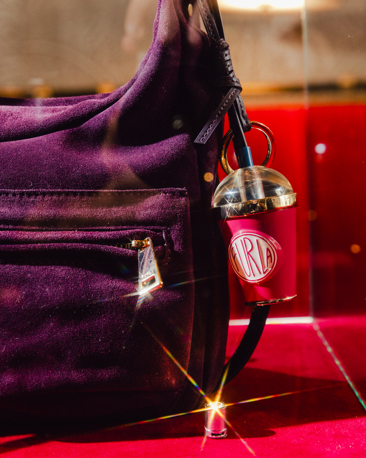 Close-up of a Furla Lynette bag and cinema-themed charm