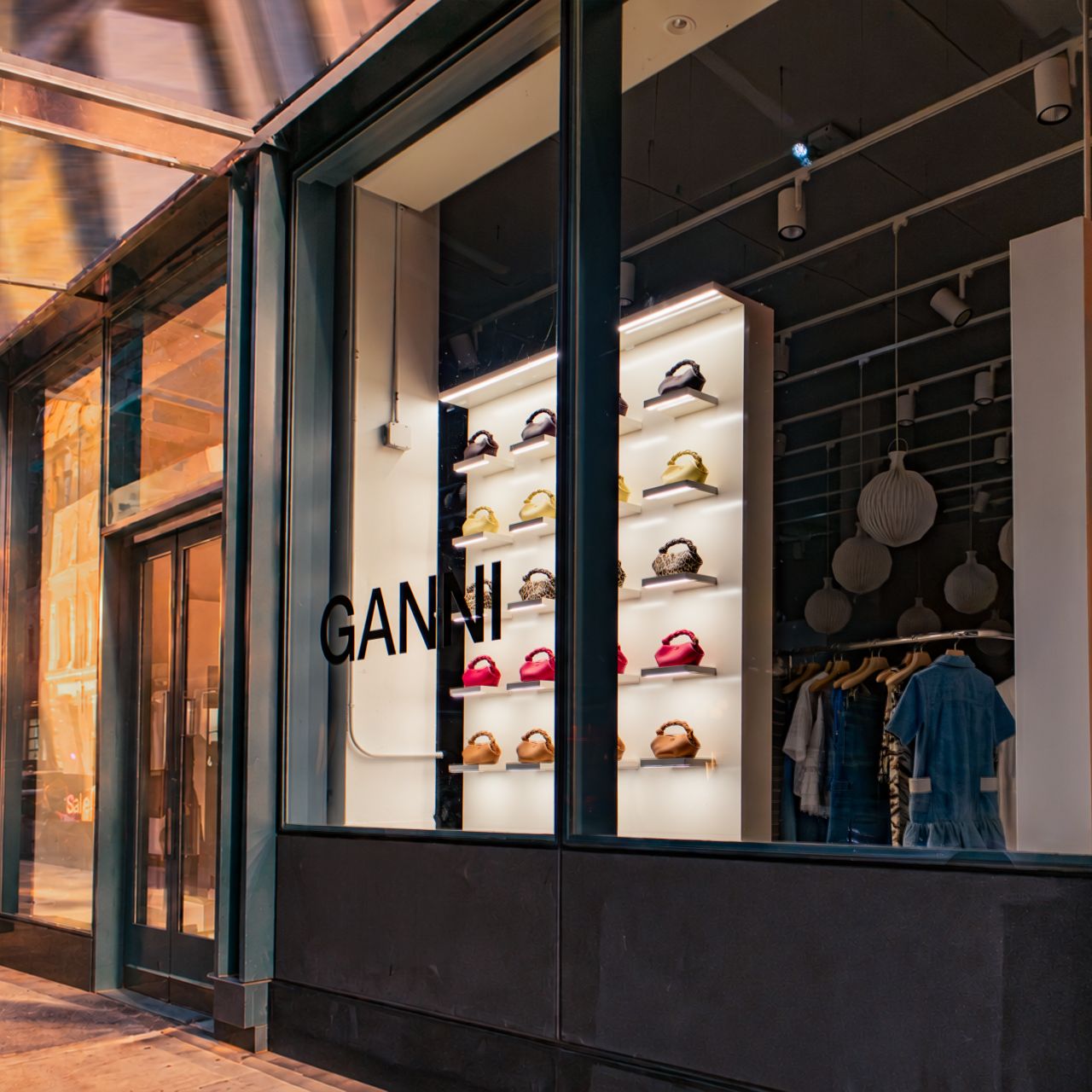 Street-level view of the GANNI Soho window and its handbag fixture