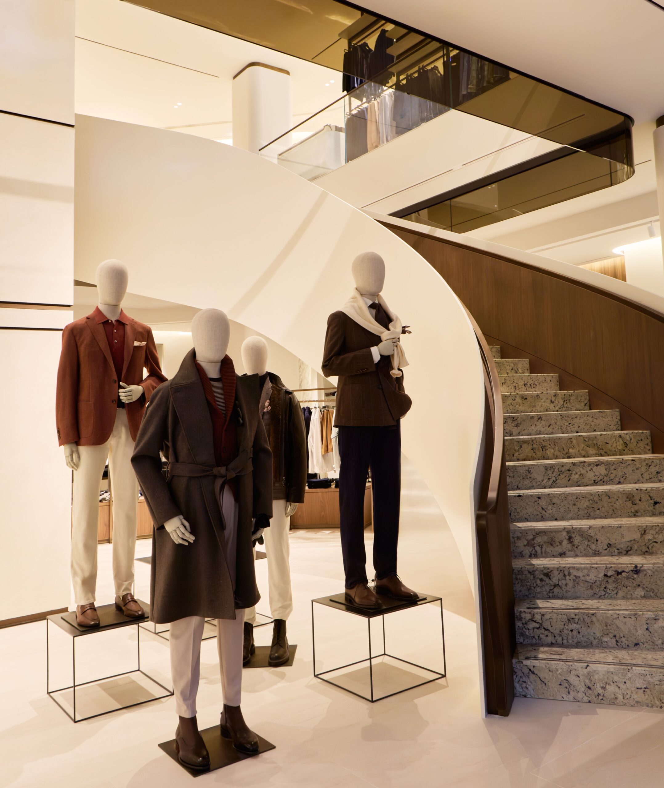 Tailored menswear mannequins beside the staircase inside Harry Rosen's flagship