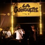 Rappers perform beneath JD Sports and Saucony branding at the Marseille Guinguette event
