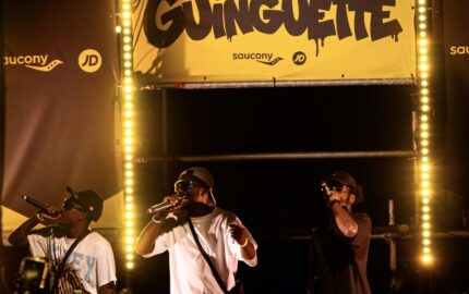 Rappers perform beneath JD Sports and Saucony branding at the Marseille Guinguette event