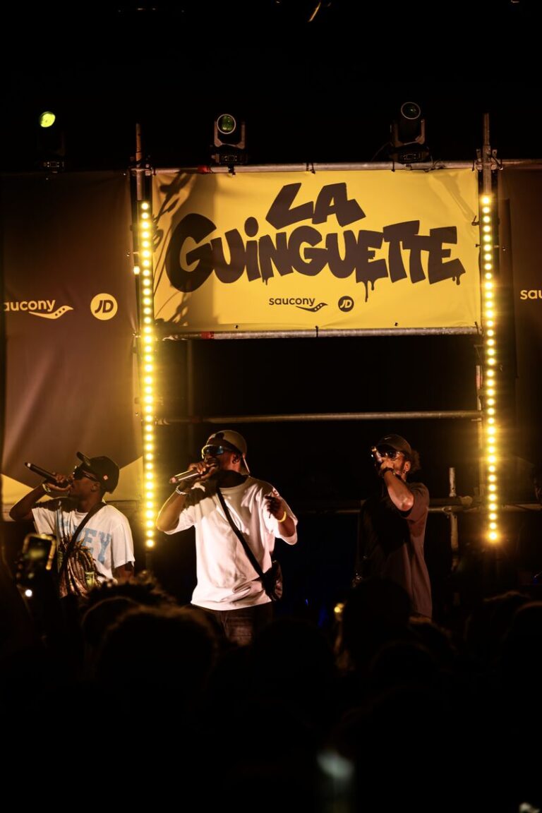 Rappers perform beneath JD Sports and Saucony branding at the Marseille Guinguette event