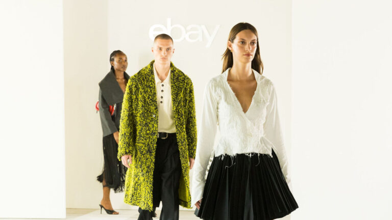 Three models walk beneath the eBay logo at its 2026 London Fashion Week Endless Runway show