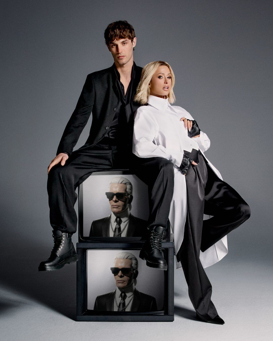 Paris Hilton and Kit Butler beside stacked televisions in the From Paris With Love campaign