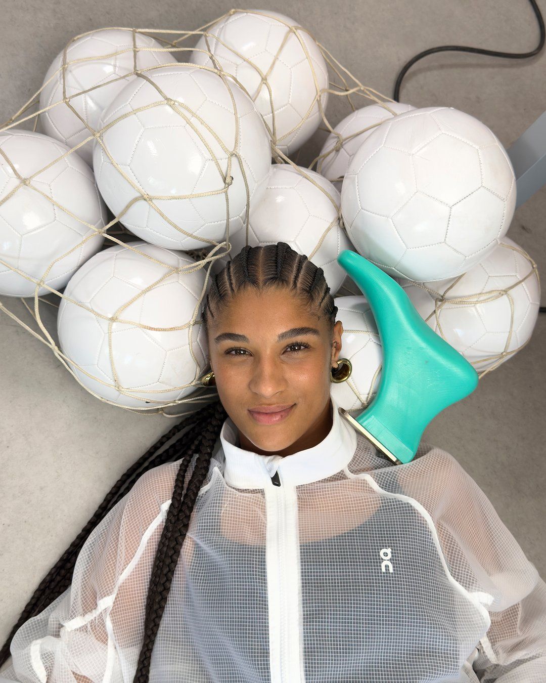 Sydney Schertenleib surrounded by footballs in the On campaign