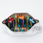 Silver Coco Bag with striped lining and packaged Unreal snacks.