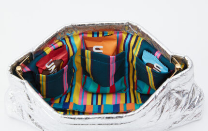 Silver Coco Bag with striped lining and packaged Unreal snacks.