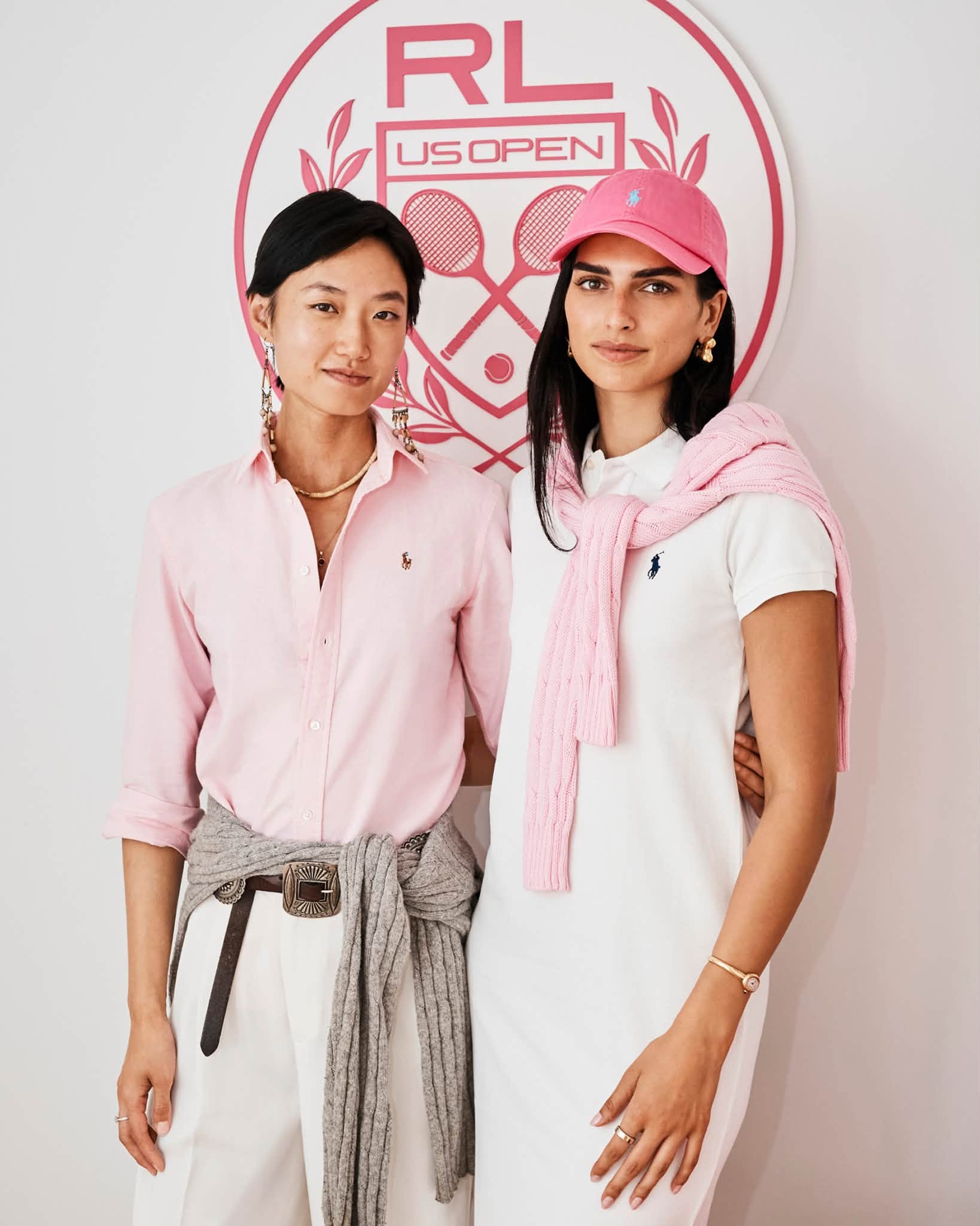 Two guests in pink and white outfits at Ralph Lauren's US Open suite.