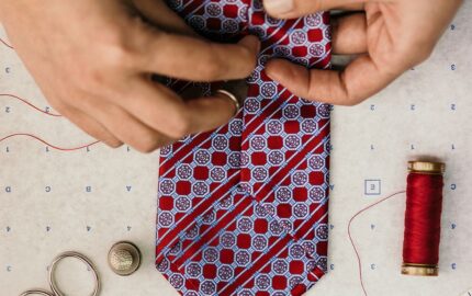 Hands working on a patterned Stefano Ricci silk tie