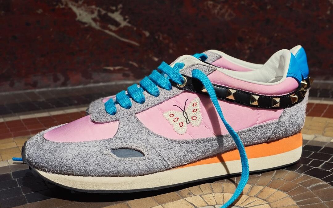Valentino Garavani Stud Up sneakers with pink panels, turquoise laces, butterfly embroidery and studded detailing.