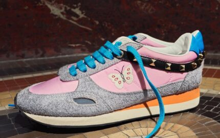 Valentino Garavani Stud Up sneakers with pink panels, turquoise laces, butterfly embroidery and studded detailing.
