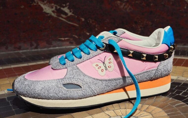 Valentino Garavani Stud Up sneakers with pink panels, turquoise laces, butterfly embroidery and studded detailing.