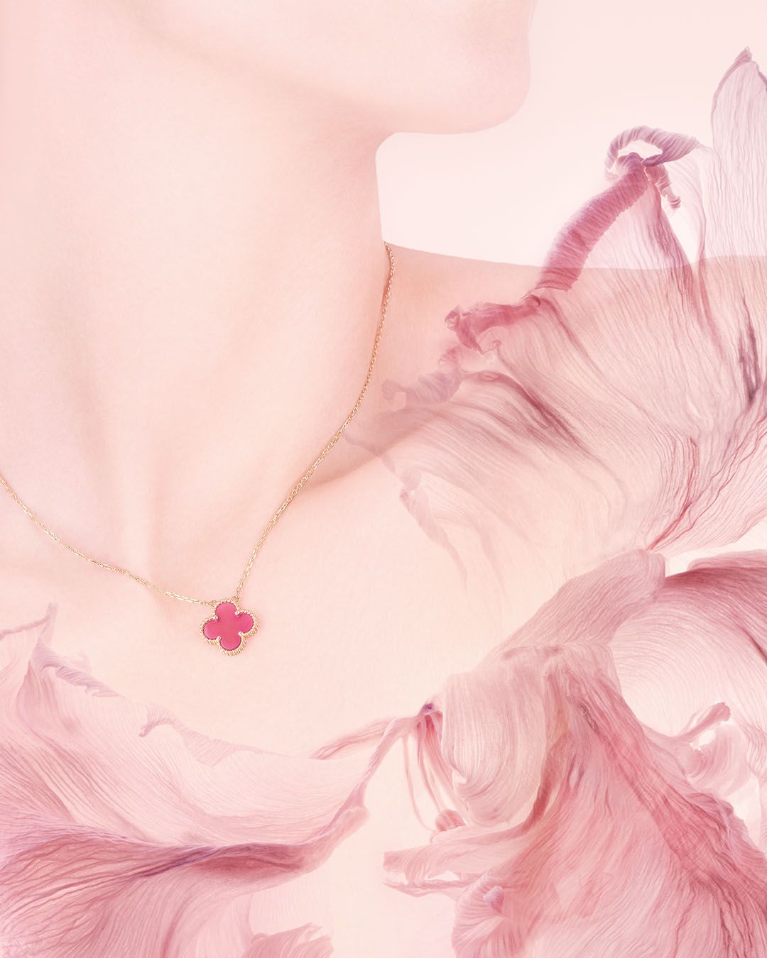 Van Cleef & Arpels pink-enamel Alhambra pendant worn with a pale pink textured garment