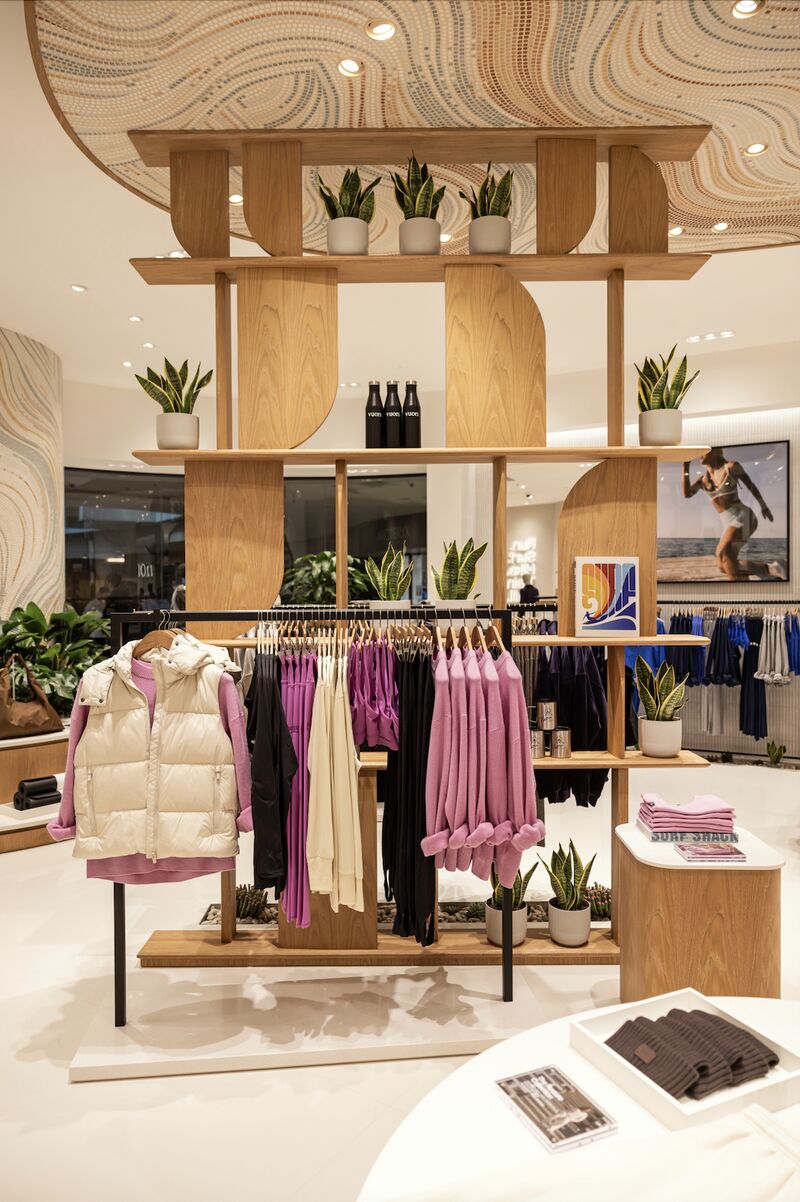 Apparel displays and wood shelving inside Vuori's Beijing Indigo store