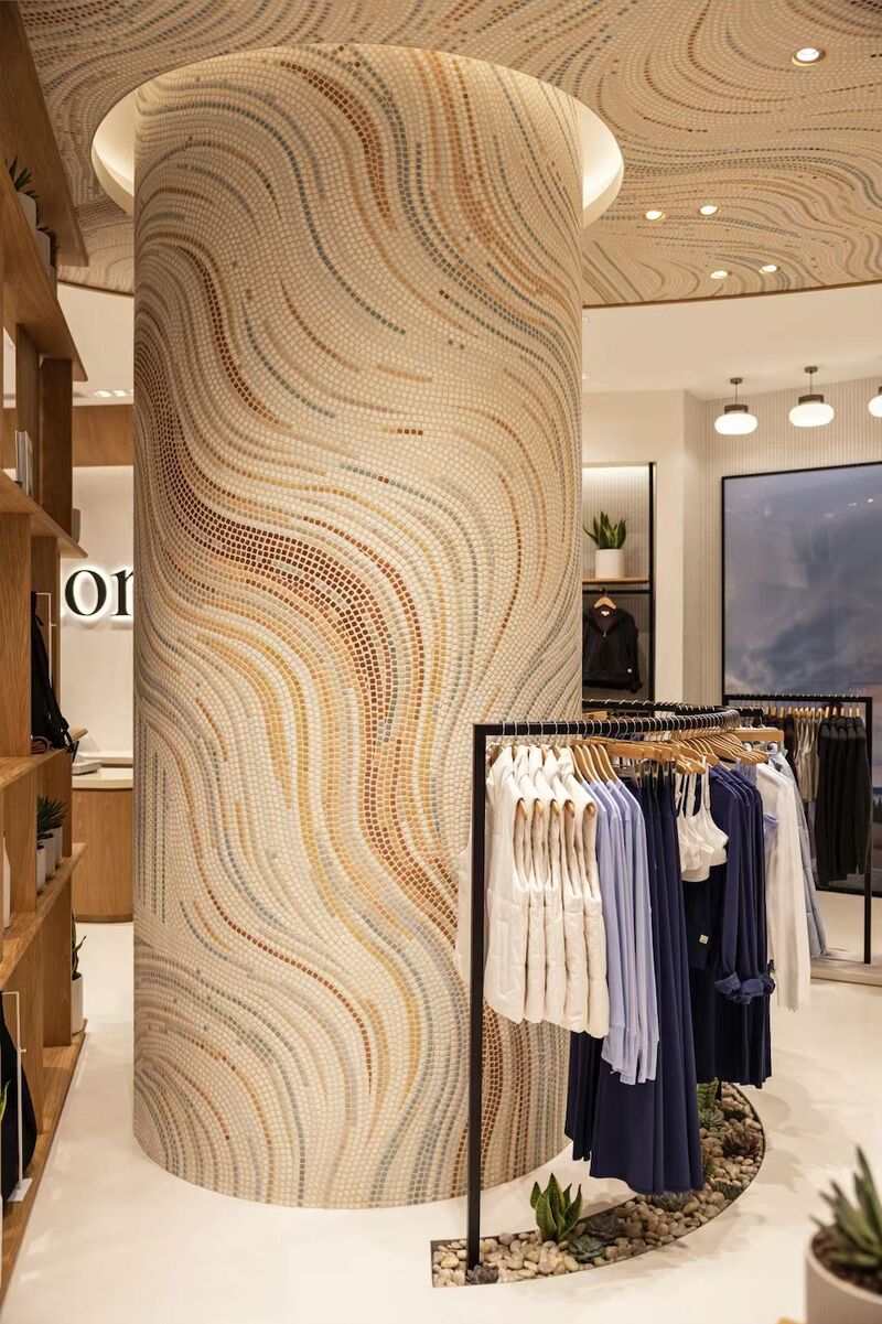 Mosaic-clad column and apparel racks inside Vuori's Beijing Indigo store