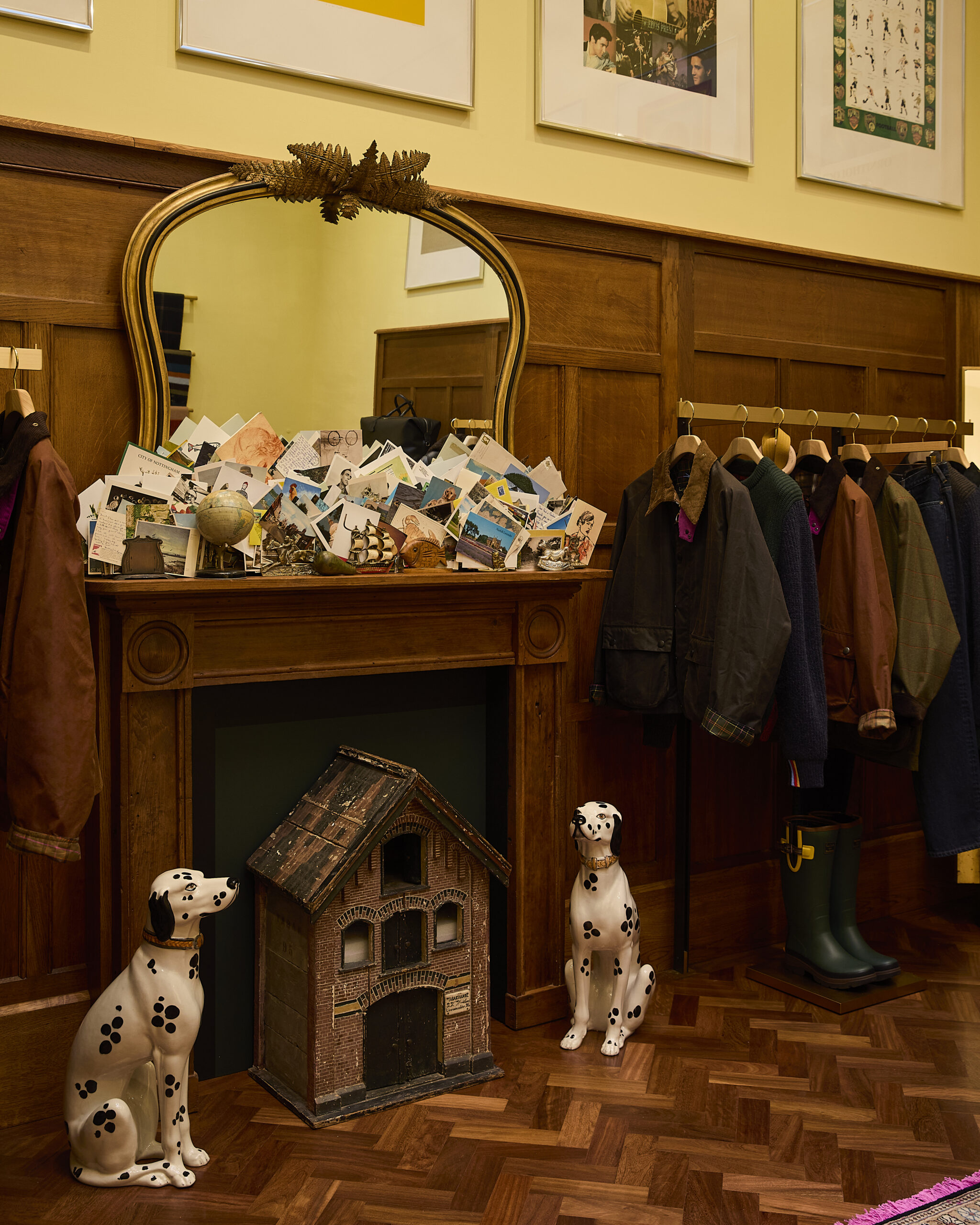 Mantelpiece with postcards, a mirror, model building and ceramic dogs at Paul Smith Madison Avenue