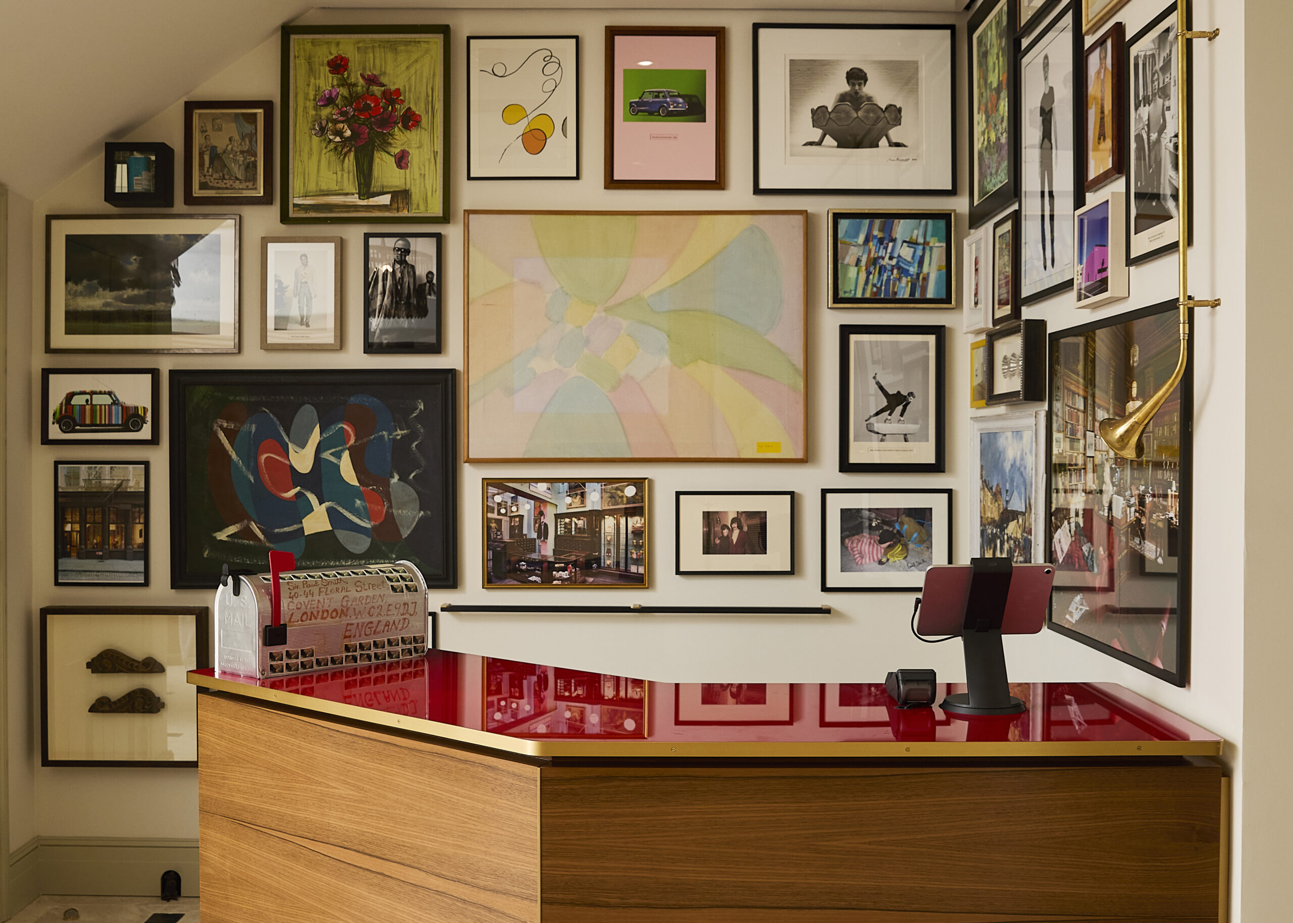 Paul Smith cash desk beneath a gallery wall of paintings, photographs and prints