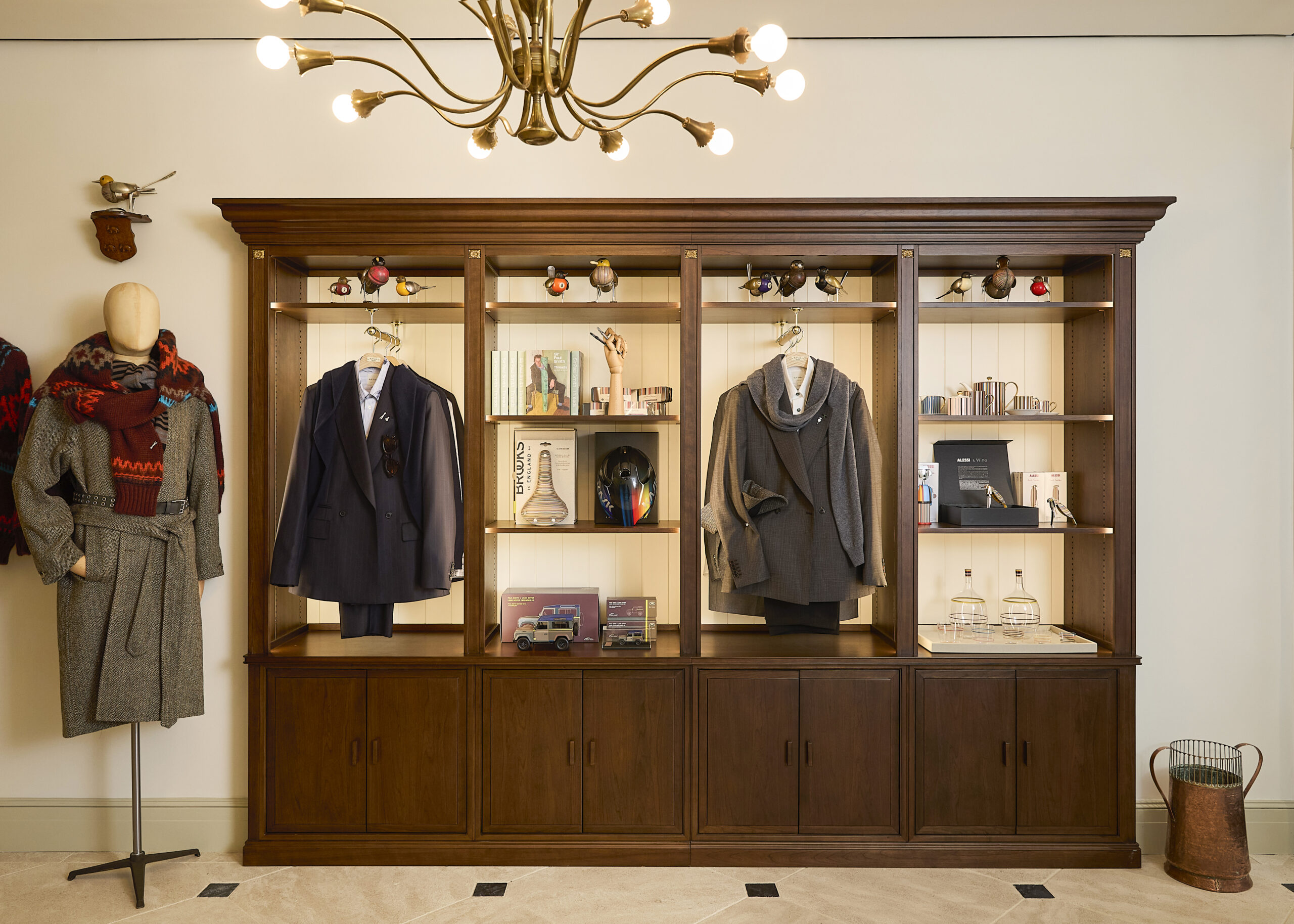 Tailored jackets and accessories displayed in wooden cabinetry at Paul Smith Madison Avenue