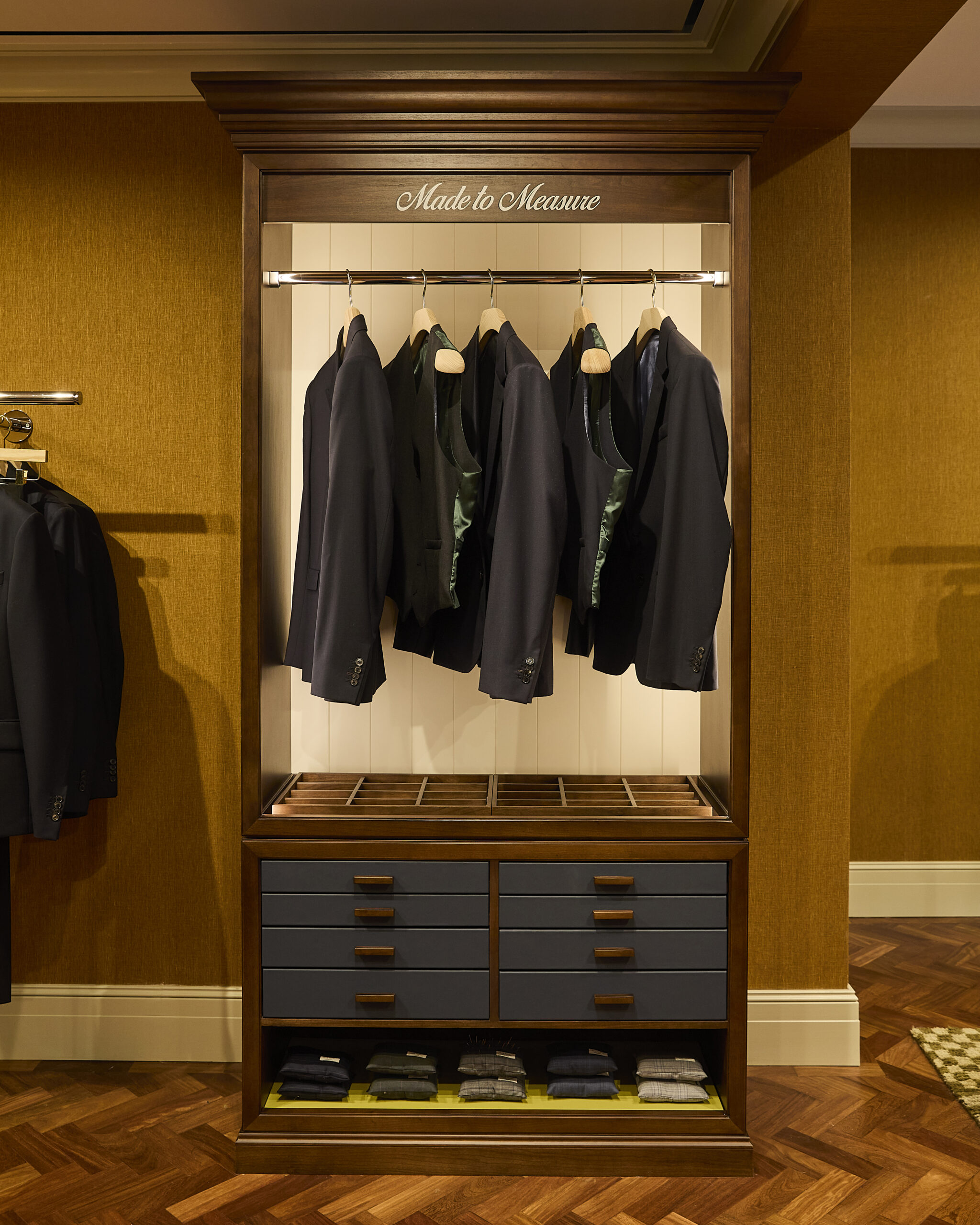 Made to Measure jackets in a wooden display cabinet at Paul Smith Madison Avenue