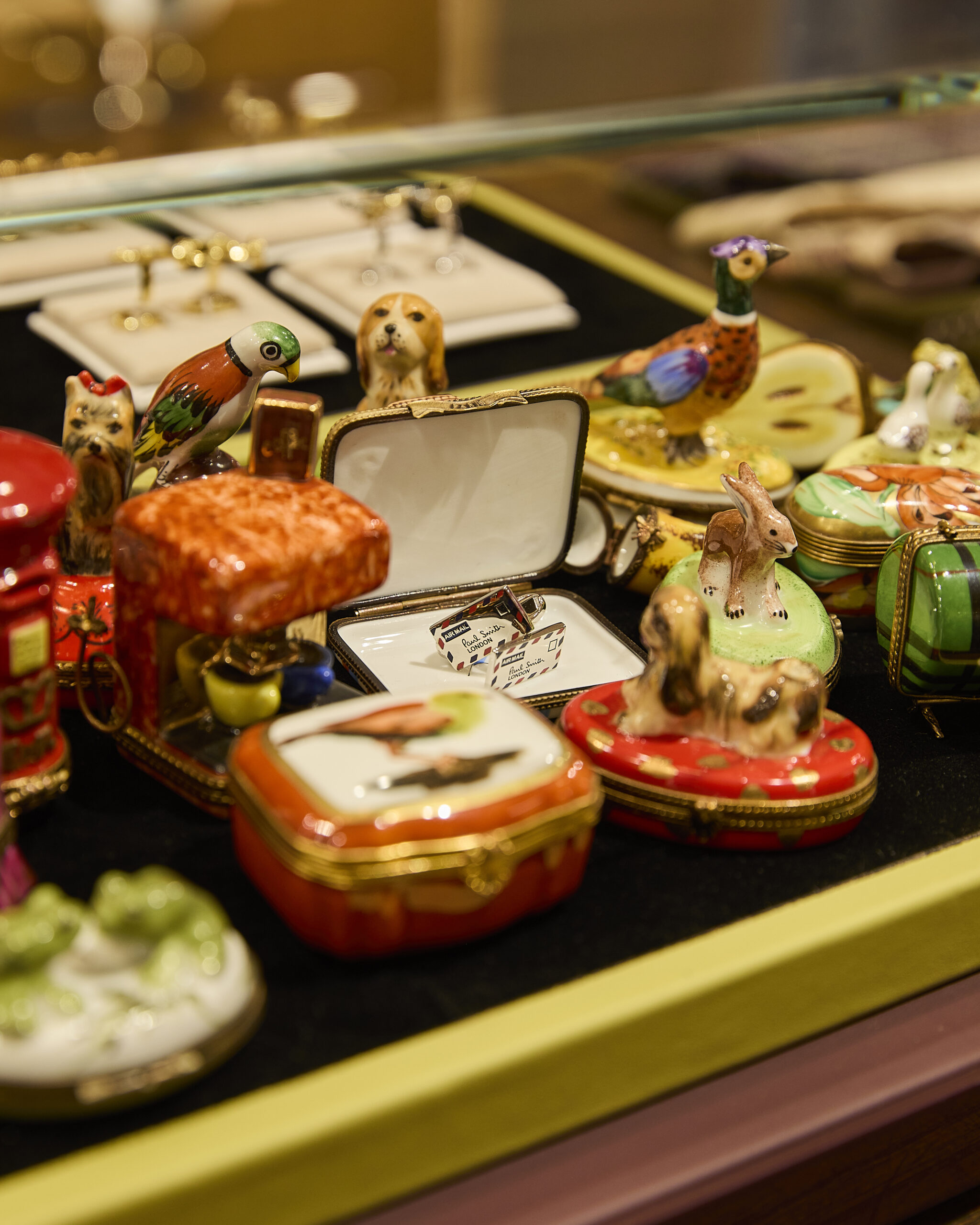 Decorative animal boxes and cufflinks in a display case at Paul Smith Madison Avenue