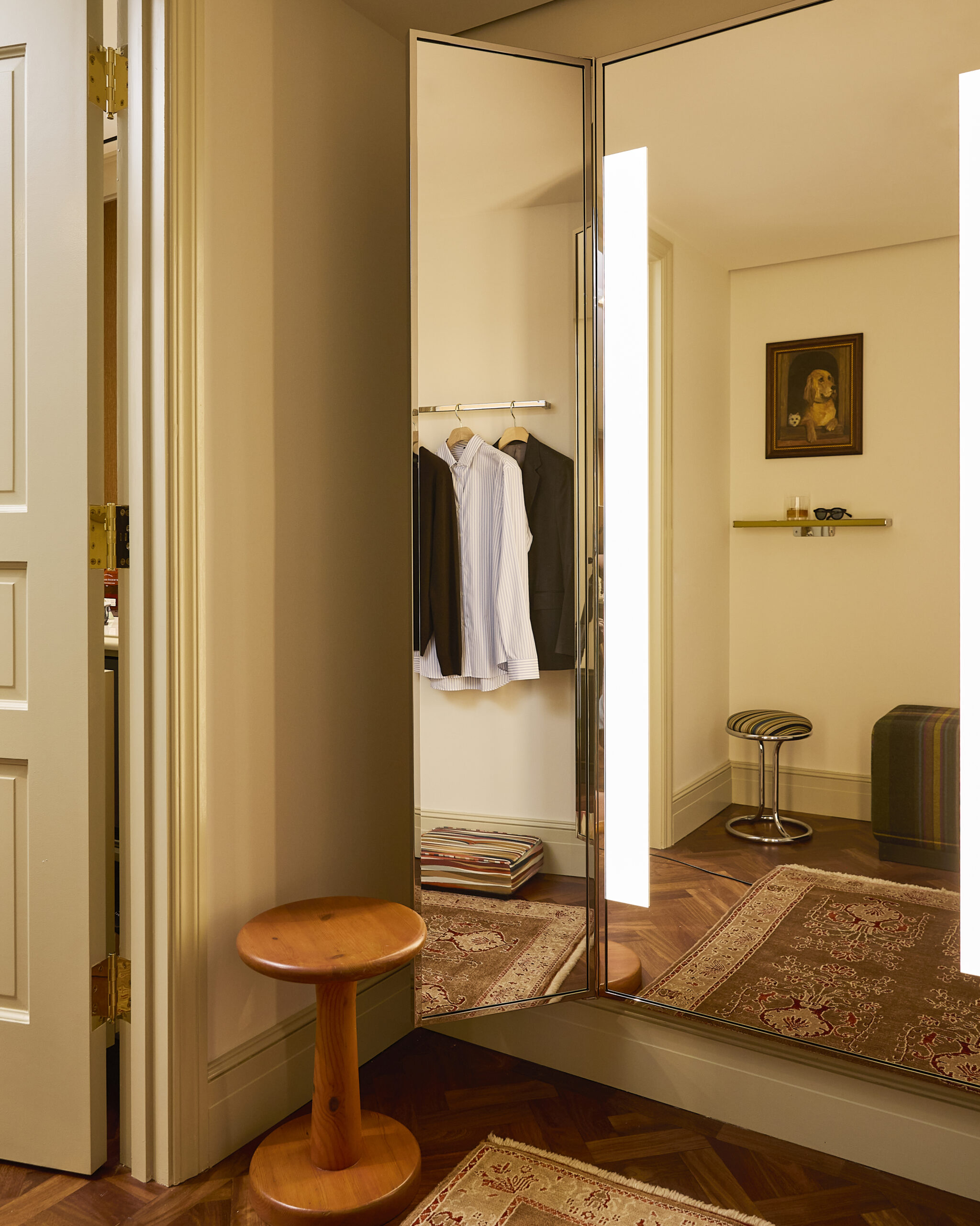 Mirrored fitting room with clothing and stools at Paul Smith Madison Avenue