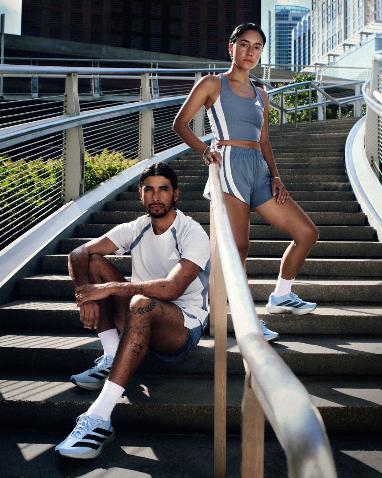 Two runners wearing adidas Chicago Marathon apparel on outdoor steps