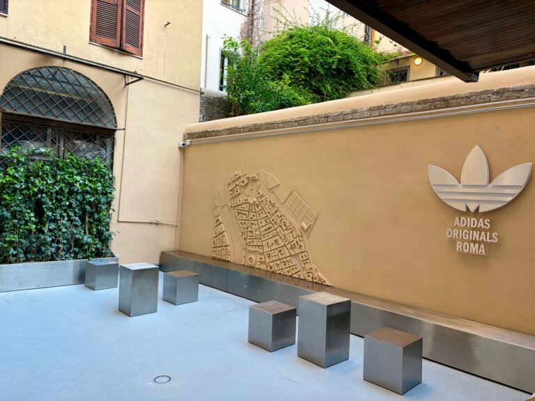 Courtyard at the adidas Originals Via del Babuino store with a raised street-map motif, metal seats and adidas Originals Roma branding.