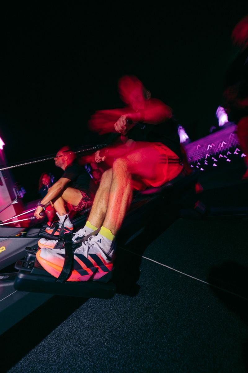Participant uses a rowing machine while wearing adidas footwear
